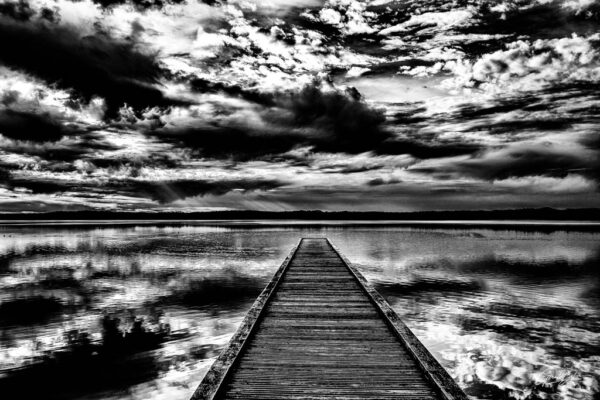 Le ponton sur le lac avec un beau ciel nuageux en noir et blanc