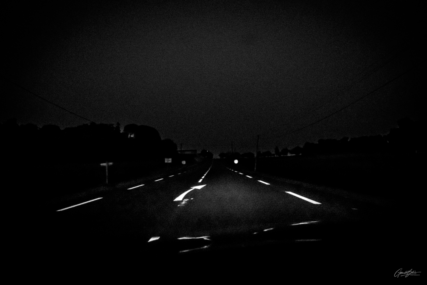 De nuit , en voiture sur la route, les phares éclairent la flèche sur la route